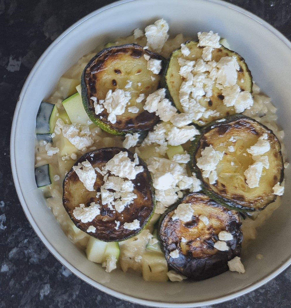 Courgette risotto topped with seared rounds and feta